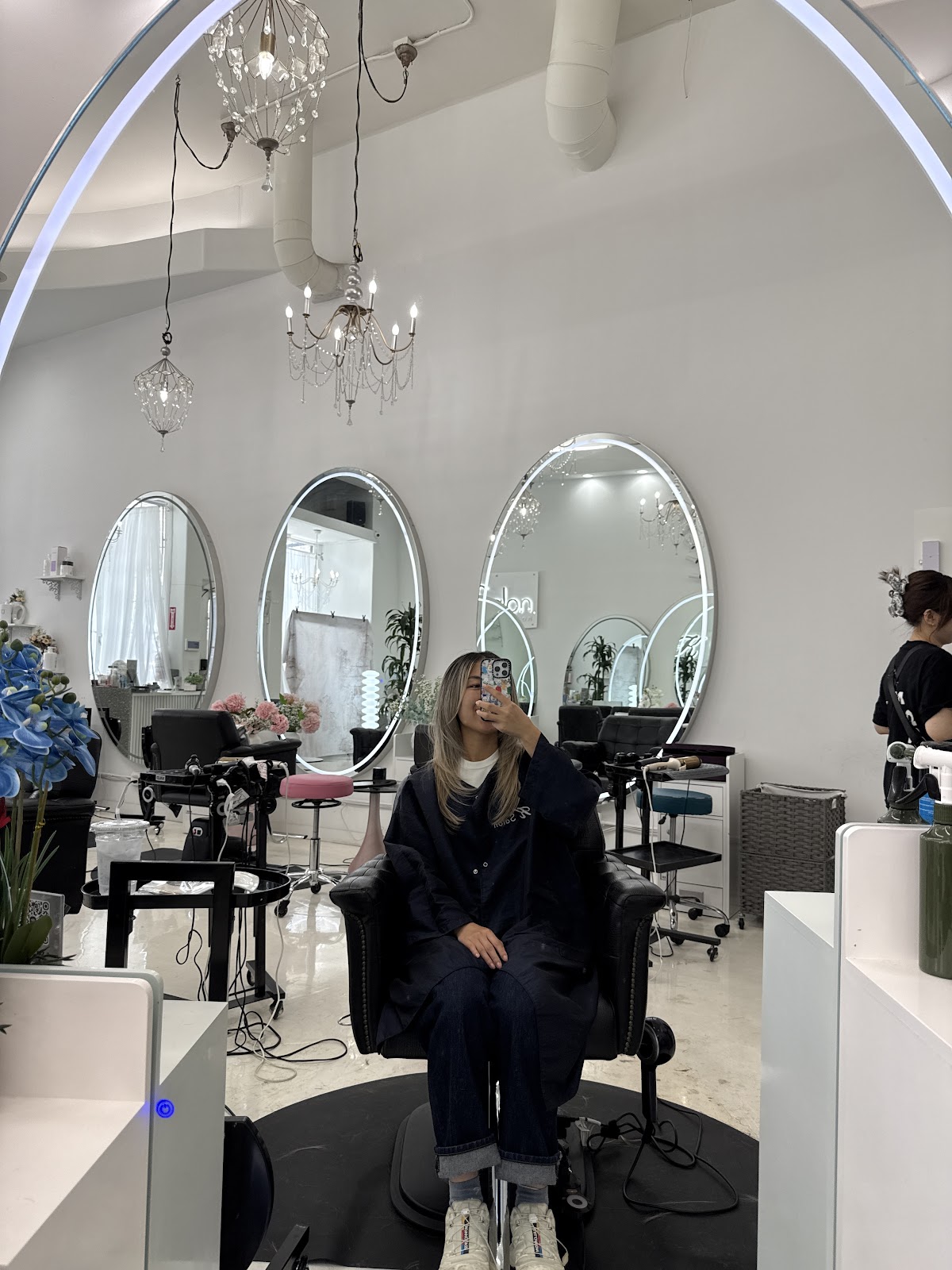 The salon floor at K Salon, with arched mirrors, marble surfaces and chandeliers
