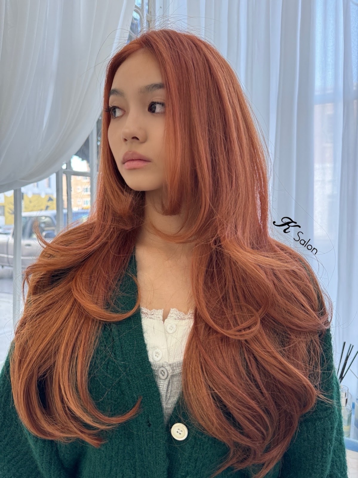 A client with long copper red layers, colored and cut at K Salon